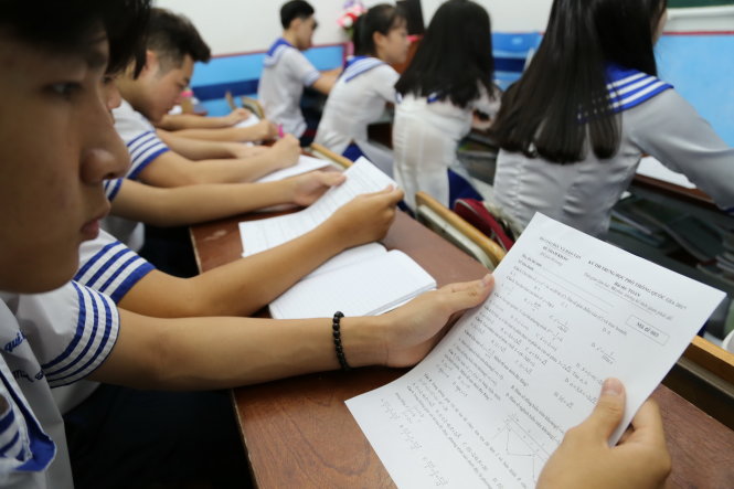 Học sinh lớp 12 Trường THPT Nhân Việt (Q.Tân Phú, TP.HCM) xem đề tham khảo được trường in phát cho học sinh, sau khi Bộ GD-ĐT công bố chiều 14-5 - Ảnh: NHƯ HÙNG