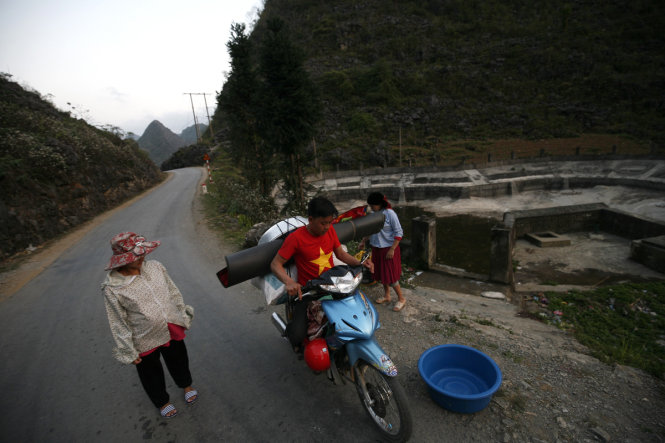 Gia đình anh Pố, gần nhà Mai và Giâm cũng một tuần dùng xe máy chở đồ tới hồ để giặt giũ- Ảnh: NAM TRẦN