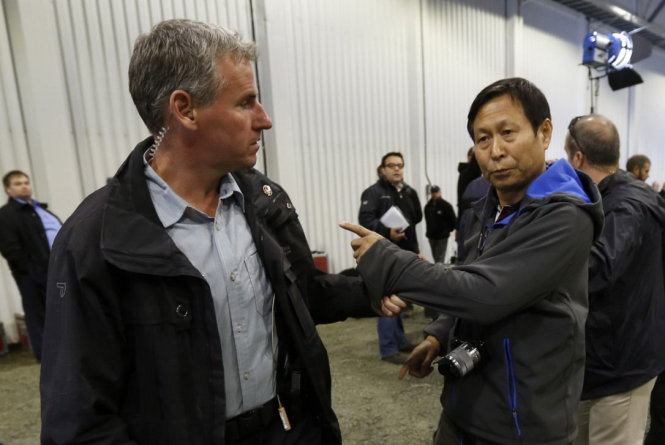 Nhân viên an ninh đưa phóng viên của Nhân dân Nhật báo (phải) ra ngoài vì người này xô đẩy nữ trợ lý của thủ tướng Canada - Ảnh: Reuters