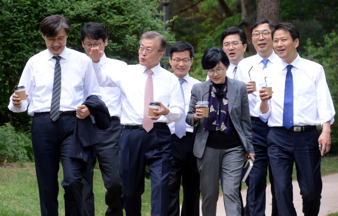 Dàn nhân viên thân cận của tổng thống Moon (thứ ba từ trái sang) cùng ông giản dị với áo trắng - cà vạt trong sân vườn Phủ tổng thống. Hình ảnh này khiến người dân thích thú vì bình dị - Ảnh: Reuters