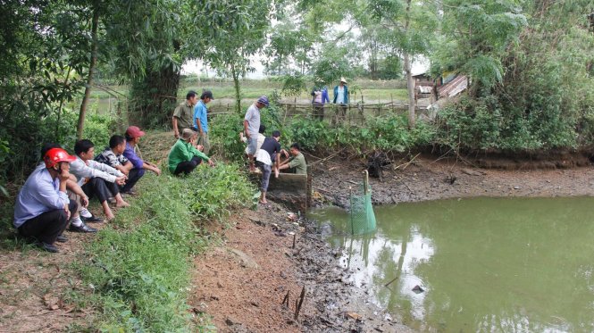 Công an huyện Vĩnh Linh đang xả hồ cá một người dân để tìm con dao gây án - Ảnh: Ngọc Vũ