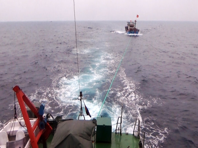 CSB 2006 lai kéo tàu cá bị nạn về cửa Lạch Quèn - Ảnh: Lam Giang