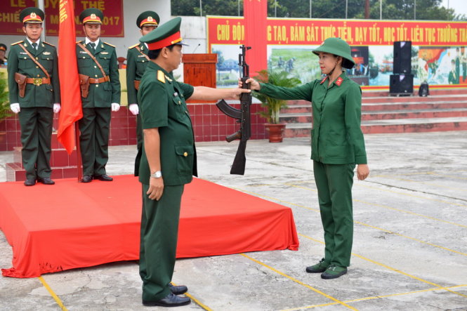 Chiến sĩ Chung Thị Cẩm Hồng đại diện nhận vũ khí từ thủ trưởng -Ảnh: DUYÊN PHAN