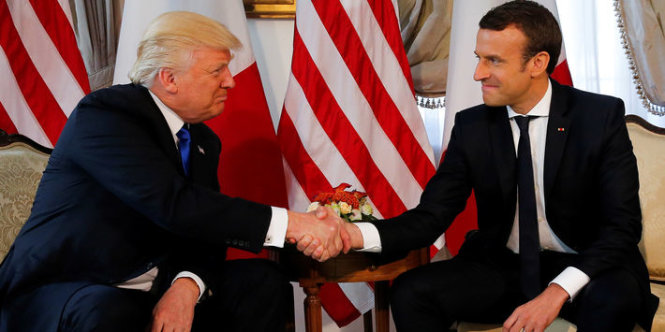 Cú bắt tay thể hiện vị thế lãnh đạo của ông Macron (phải) - Ảnh: Reuters