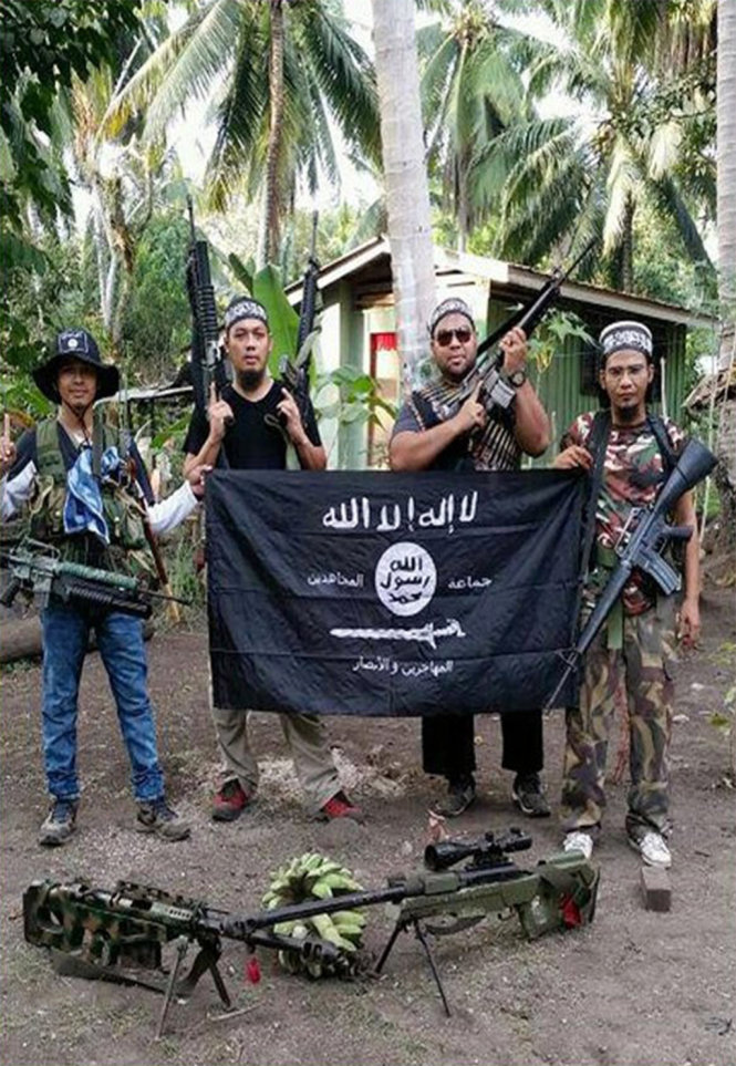Mahmud Ahmad (thứ hai từ trái sang) chụp ảnh với cờ IS - Ảnh: The Straits Times