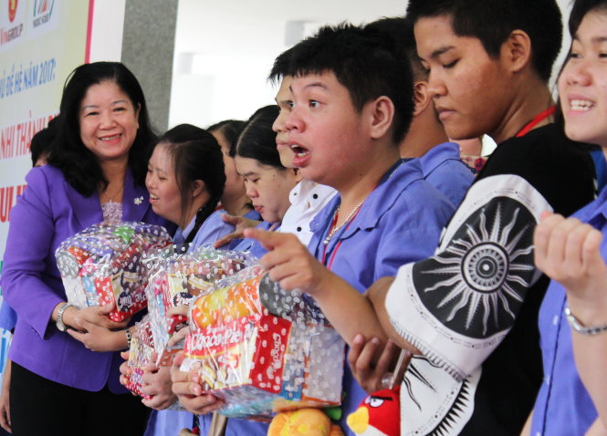 Phó trưởng Ban dân vận Thành ủy TP.HCM Nguyễn Thị Bích Ngọc (trái) trao quà cho các bạn nhỏ khuyết tật của TP.HCM trong ngày hội Kết nối yêu thương - Ảnh: Q.L.