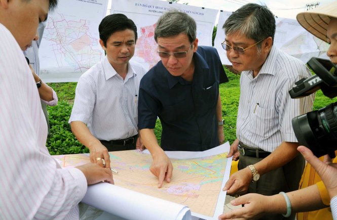 Chủ tịch UBND tỉnh Đồng Nai Đinh Quốc Thái (giữa) xem bản đồ quy hoạch sử dụng đất tại khu vực quy hoạch sân bay Long Thành (ảnh chụp tháng 7-2016) -
 Ảnh: A Lộc