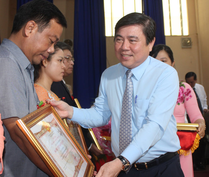 Chủ tịch UBND TP Nguyễn Thành Phong trao danh hiệu Bà Mẹ Việt Nam Anh hùng cho gia đình của các mẹ - Ảnh: N.N