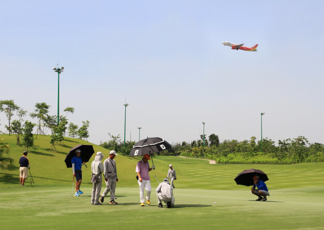 Khách chơi golf trong khi máy bay lên xuống liên tục tại sân bay Tân Sơn Nhất (TP.HCM) - Ảnh: VÂN TRƯỜNG