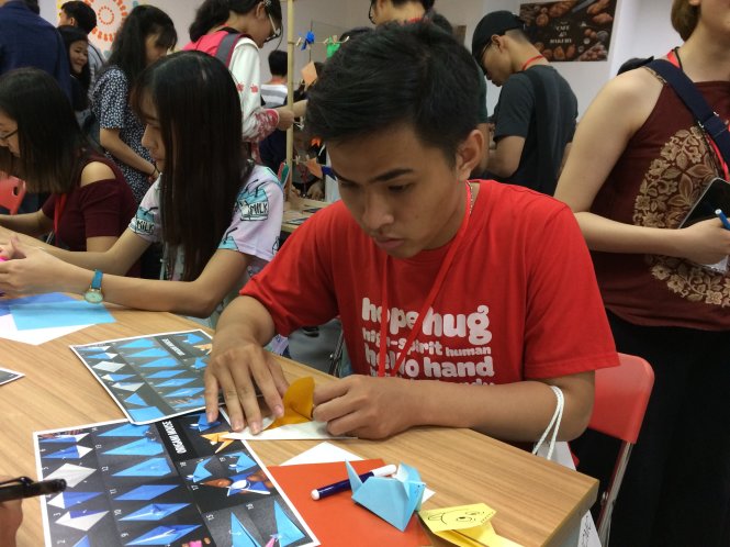 Các bạn trẻ tham gia trải nghiệm gấp giấy origami - Ảnh: MINH PHƯỢNG