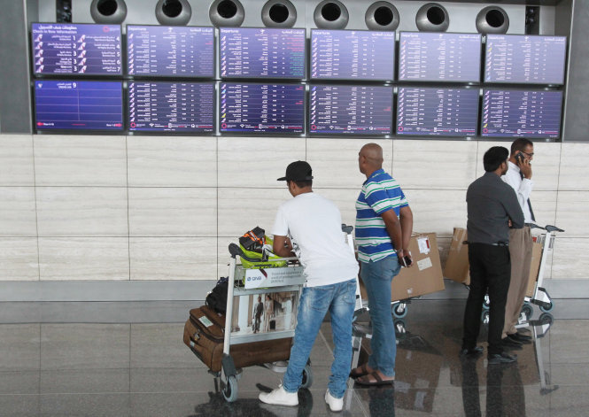 Hành khách kiểm tra thông tin tại sân bay Hamad ở Doha, Qatar. Căng thẳng đã khiến nhiều gia đình trong khu vực bị ly tán và các kết nối thương mại bị cắt đứt. - Ảnh: Reuters