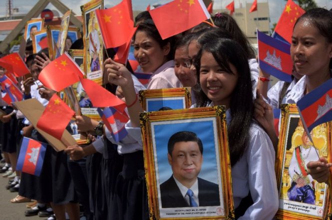 Học sinh Campuchia ôm chân dung ông Tập Cận Bình, vẫy cờ Trung Quốc khi ông đến thăm Campuchia tháng 10-2016 - Ảnh: AFP