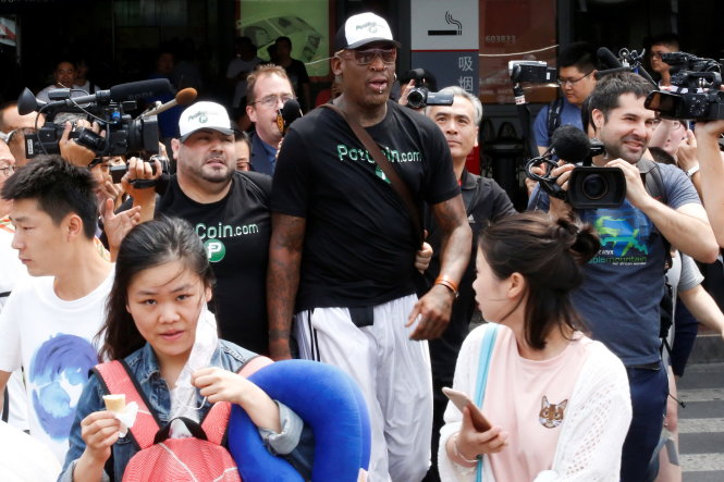 Cựu danh thủ bóng rổ Mỹ Dennis Rodman trong vòng vây báo chí khi về đến sân bay ở Bắc Kinh ngày 17-6. Ông đã có chuyến thăm người bạn cũ Kim Jong Un tại Bình Nhưỡng với món quà là... quyển sách của Donald Trump! - Ảnh: Reuters