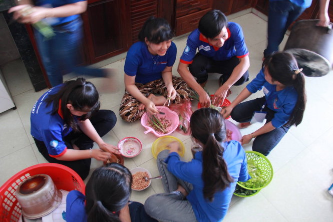 Các tình nguyện viên “đàn em” tham gia nấu ăn trong lúc các anh chị thi - Ảnh: Trần Mai