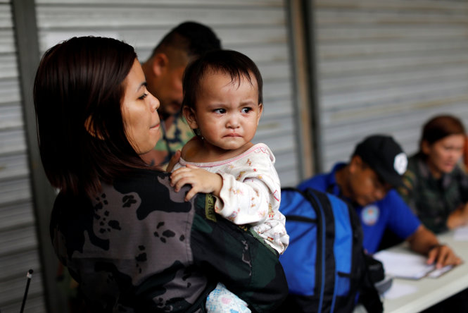 Một em bé được tình nguyện viên bế sau khi được giải cứu khỏi vùng chiến sự ở Marawi ngày 25-6 - Ảnh: Reuters