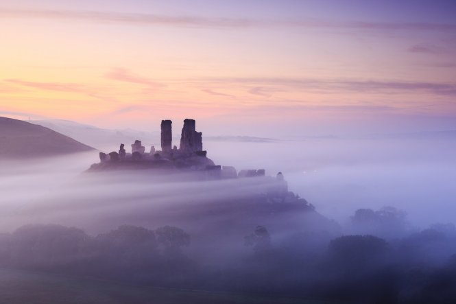 Alternatively, stay closer to home and admire English country scenes like this dawn view of Corfe Castle in Dorset © UIG via Getty Images