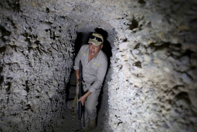 Một binh sĩ Iraq mang súng đi trong đường hầm của IS ở ngôi làng Har Bardun, Iraq - Ảnh: Reuters