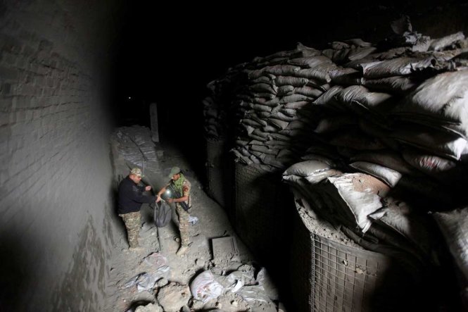 Các thành viên thuộc lực lượng phản ứng nhanh của Iraq đang kiểm tra một khu hầm IS dùng làm trại huấn luyện ngầm của chúng ở khu vực sườn đồi trông ra thành phố Mosul, Iraq - Ảnh: Reuters