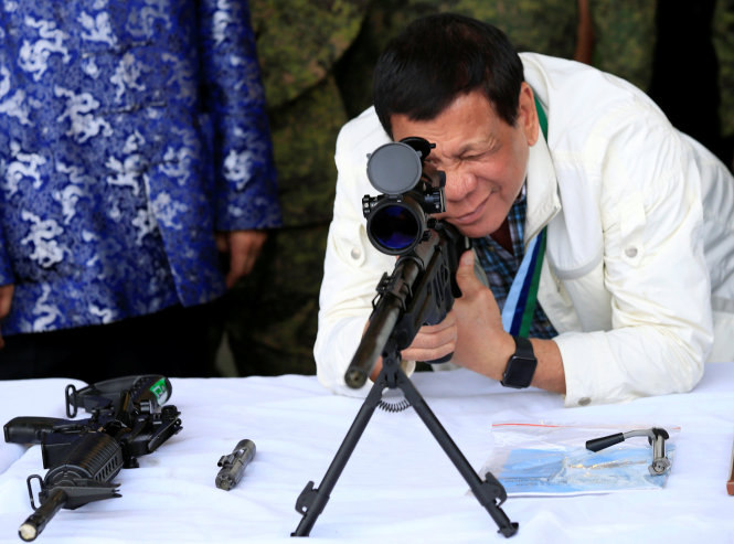 Tổng thống Philippines Rodrigo Duterte ngắm thử một khẩu súng bắn tỉa do Trung Quốc cấp ngày 28-6 - Ảnh: Reuters