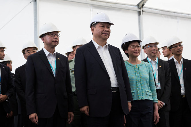 Ông Tập Cận Bình (giữa) cùng lãnh đạo đặc khu hành chính Hong Kong, bà Lâm Trịnh Nguyệt Nga (phải) tới thăm một phần đang xây dựng của cây cầu Hong Kong - Chu Hải - Macau tại Hong Kong - Ảnh: Reuters