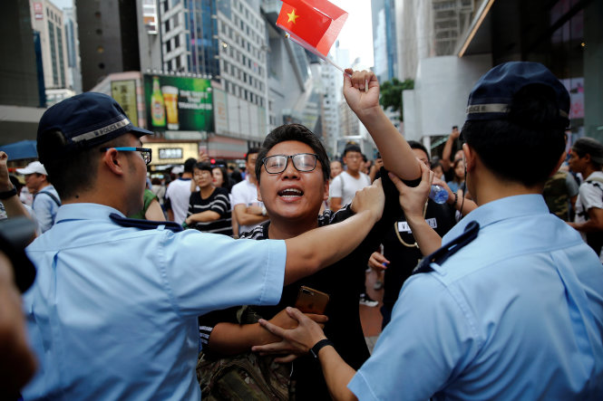 Cảnh sát ngăn cản một người ủng hộ chính quyền Trung Quốc đại lục tiến vào khu vực những người biểu tình ủng hộ Hong Kong độc lập, dân chủ - Ảnh: Reuters