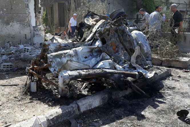 Người dân đến xem chiếc xe bom đã bị kích nổ sáng 2-7 - Ảnh: Reuters