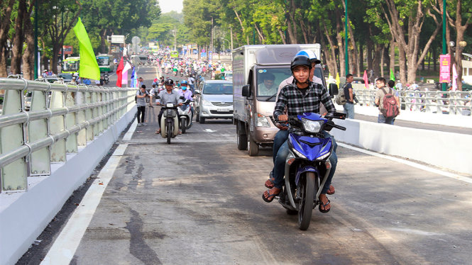 Những chiếc xe đầu tiên đi lên cầu vượt nút giao Nguyễn Kiệm - Nguyễn Thái Sơn - Ảnh: Hồng Ly