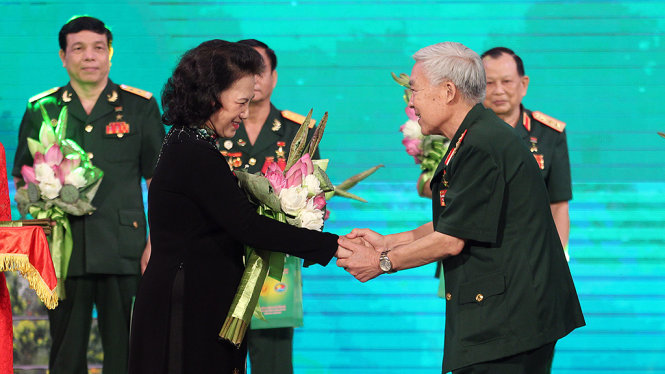 Chủ tịch Quốc hội Nguyễn Thị Kim Ngân trao tặng hoa cho một cựu chiến binh - Ảnh: Nguyễn Khánh