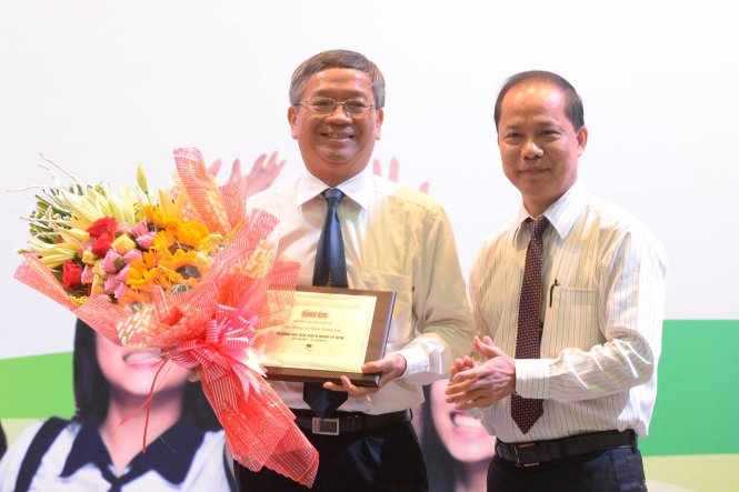 Ông Lê Xuân Trung - Phó tổng biên tập báo Tuổi Trẻ, tặng hoa cho lãnh đạo Trường ĐH Bách Khoa tại ngày hội - Ảnh: Hữu Khoa