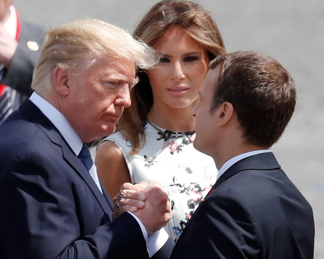Tổng thống Trump (trái) và tổng thống Macron có thêm cú bắt tay thân mật sau cuộc diễu binh sáng 14-7 - Ảnh: Reuters