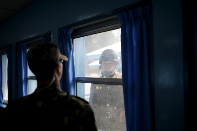 Binh sĩ Triều Tiên (phải) và Hàn Quốc giữ vị trí canh gác ở phòng hội nghị của tòa nhà phái bộ LHQ trong làng Bàn Môn Điếm - Ảnh: Reuters