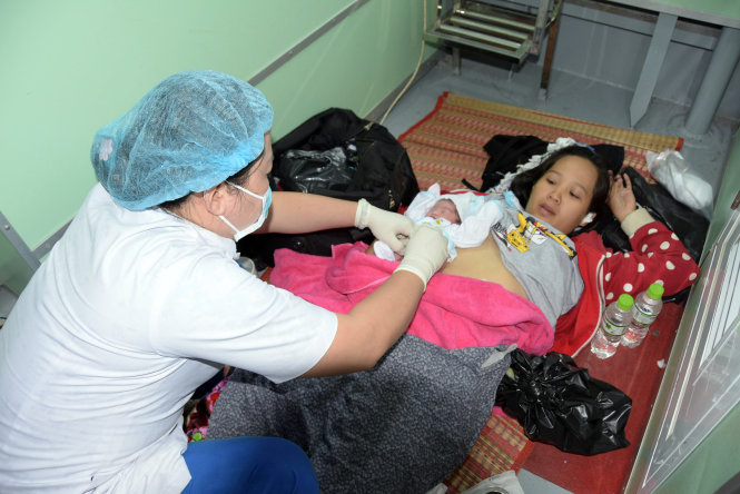 Bác sĩ Bệnh viện Đa khoa Kiên Giang khám và chăm sóc hai mẹ con chị Nguyễn Hoàng Thanh Thảo ngay sau khi tàu cập bến - Ảnh: TTXVN