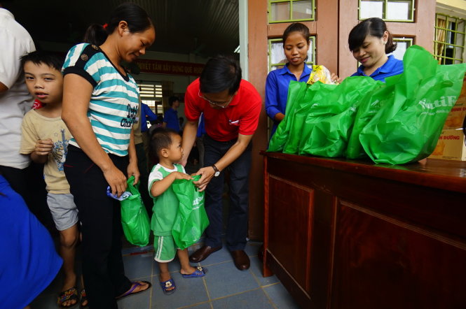 Đại diện báo Tuổi Trẻ tặng quà cho người dân khám bệnh tại xã Vĩnh Trường, huyện Gio Linh, tỉnh Quảng Trị sáng 20-7 - Ảnh: Quang Định