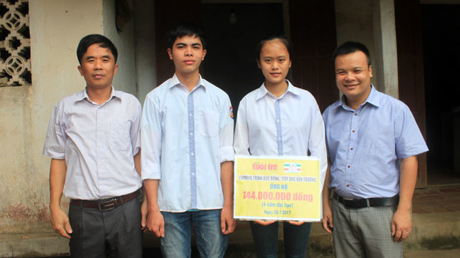 Em Trịnh Thị Hồng và Lê Hữu Hiếu (đứng giữa) cùng đại diện Tập đoàn Công Thanh và thầy giáo của hai em tại buổi trao học bổng “Tiếp sức đến trường” cho em Hồng chiều 20-7 - Ảnh: HÀ ĐỒNG