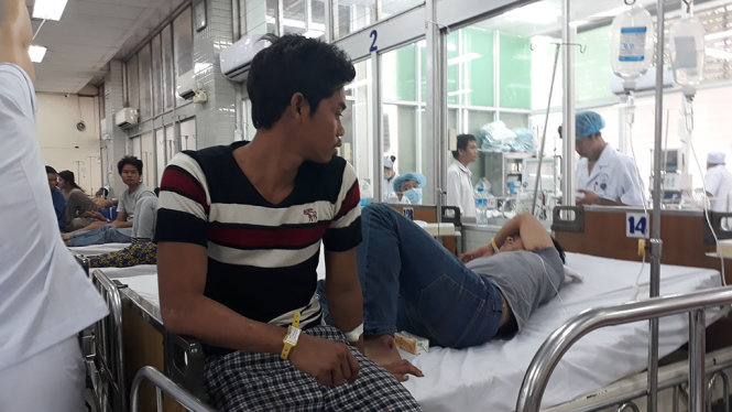 Thuyền viên Nguyễn Văn Dũng (người ngồi) của  tàu cá BĐ 31153 TSđang được cấp cứu tại bệnh viện Chợ Rẫy - Ảnh: TIẾN LONG
