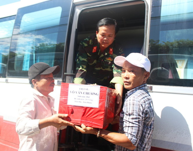 Đại tá Nguyễn Quang Ngọc cùng đồng đội đưa hài cốt liệt sĩ lên xe để trở về quê nhà ở Quảng Nam - Ảnh: UYÊN TRINH