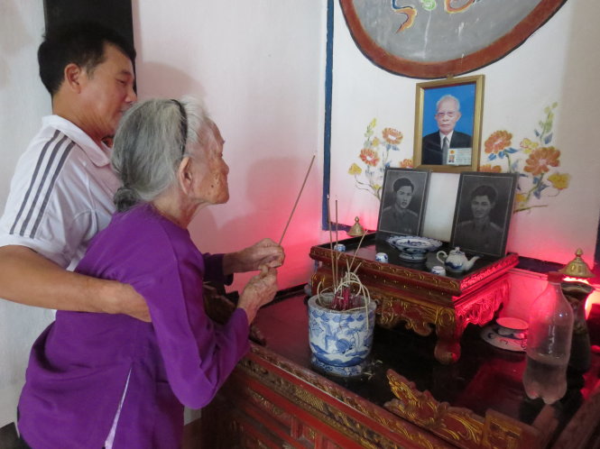 Anh thương binh Hoàng Văn Công dìu mẹ Hài đến bàn thờ thắp nhang cho hai con trai liệt sĩ   Ảnh: Vũ Toàn