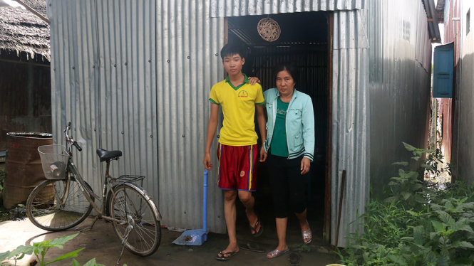 Hai mẹ con Tùng trước căn nhà ở tạm tại ấp An Trung, xã Định An, huyện Gò Quao (Kiên Giang) - Ảnh: K.NAM