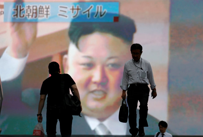 Mọi người đi qua màn hình lớn trên phố khi đang phát tin Triều Tiên bắn tên lửa ngày 4-7 ở Tokyo, Nhật Bản - Ảnh (tư liệu): Reuters