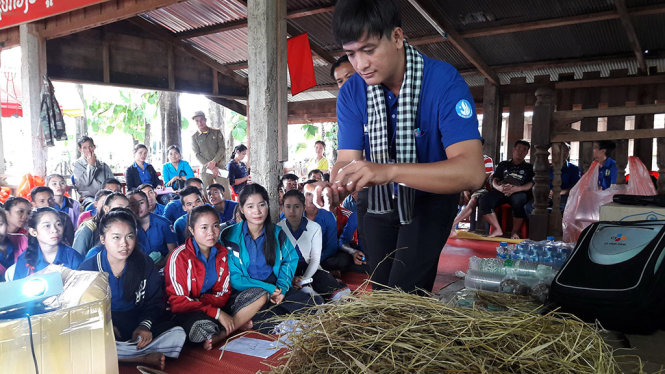Chiến sĩ tình nguyện Phan Hữu Tín tập huấn kỹ thuật trồng nấm rơm cho người dân Lào tại huyện Khong - Ảnh: QUANG PHƯƠNG