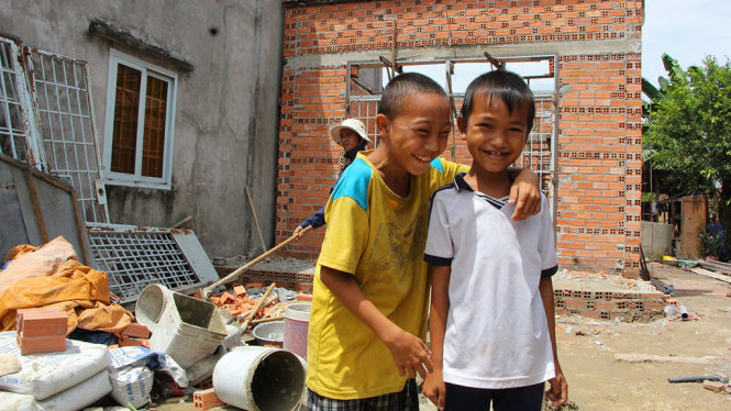 Hai đứa con chị Lê Thị Nga vui cười vì được xây tặng nhà nhân ái - Ảnh: THU TRANG