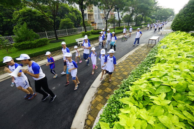 Các em nhỏ hăng hái tham gia đi bộ xung quanh khu căn hộ cao cấp Giai Việt trên đường Tạ Quang Bửu, Q.8, TPHCM sáng 6-8 - Ảnh: QUANG ĐỊNH