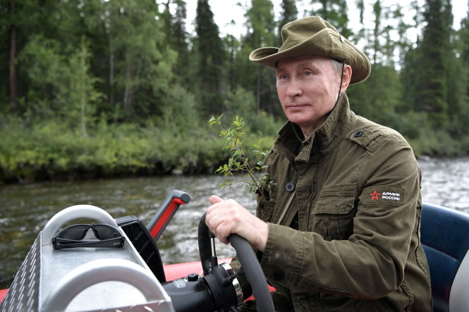 Tổng thống Putin tự tay cầm lái chiếc ca nô trên vùng hồ ở Tyva phía cực nam Siberia - Ảnh: REUTERS