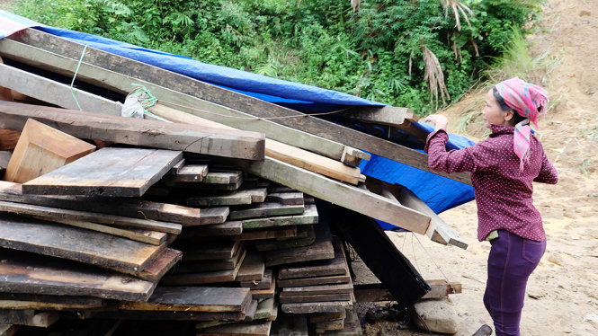 Bà Hoàng Thị Phoóng, bản Nà Én, xã Chà Tở, huyện Nậm Pồ, Điện Biên đang thu dọn phần gỗ của ngôi nhà cũ đã bị lở đất xô đổ nhà vào đầu tháng 8