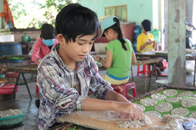 Em Nguyễn Văn Thiện, mồ côi cha, đi bóc cá để kiếm tiền phụ mẹ mua sách vở, áo quần cho năm học mới - Ảnh: HỮU KHÁ