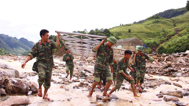 Bộ đội bắc cầu cho dân qua suối tại xã Nậm Păm (huyện Mường La, tỉnh Sơn La) - Ảnh: HÀ THANH
