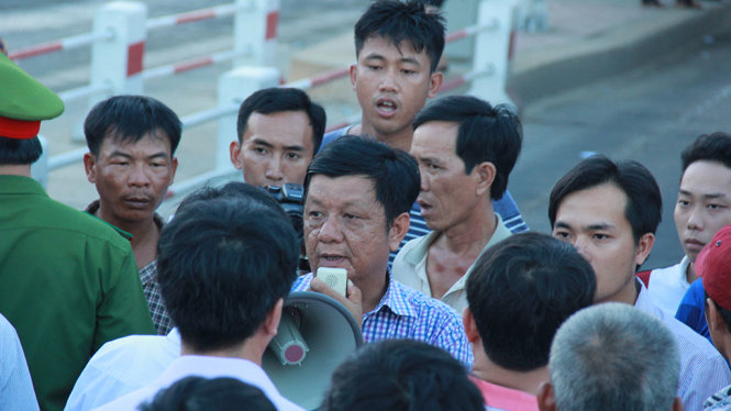 Ông Trần Ngọc Thụy, giám đốc công ty TNHH BOT Thiên Tân - Thành An trong vòng vây của người dân tại trạm thu phí - Ảnh: TRẦN MAI (chụp chiều 5-8-2016)