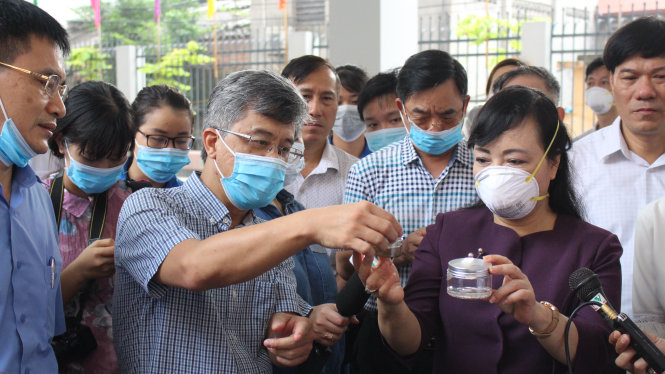 Bộ trưởng bộ Y tế Nguyễn Thị Kim Tiến quan sát hai bình chứa bọ gậy vừa được lực lượng chức năng phát hiện tại hai hộ gia đình trên địa bàn phường Thụy Khuê, Q. Tây Hồ, Hà Nội - Ảnh: CHÍ TUỆ