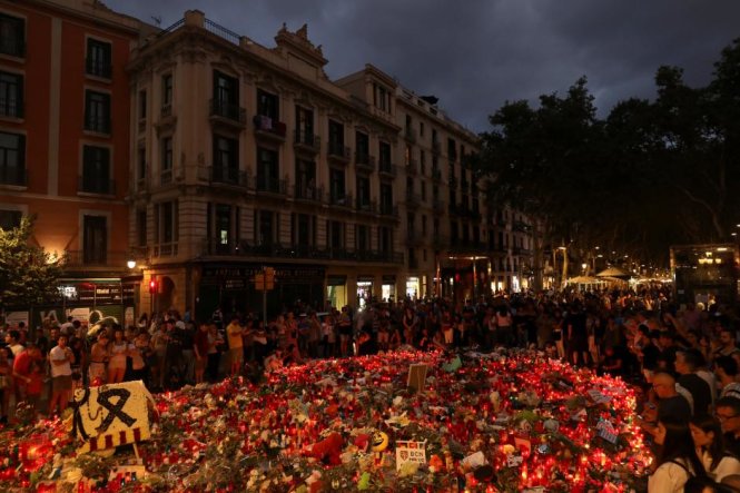 Mọi người tập trung ở khu vực tưởng niệm những nạn nhân xấu số trong vụ tấn công khủng bố ở Las Ramblas, Barcelona, Tây Ban Nha - Ảnh: Reuters