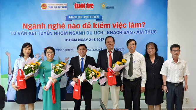 Ông Hà Thạch Hãn - Phó tổng Thư ký Tòa soạn (ngoài cùng bên phải) đại diện báo Tuổi Trẻ tặng hoa cho các vị khách mời tham gia giao lưu - Ảnh: DUYÊN PHAN